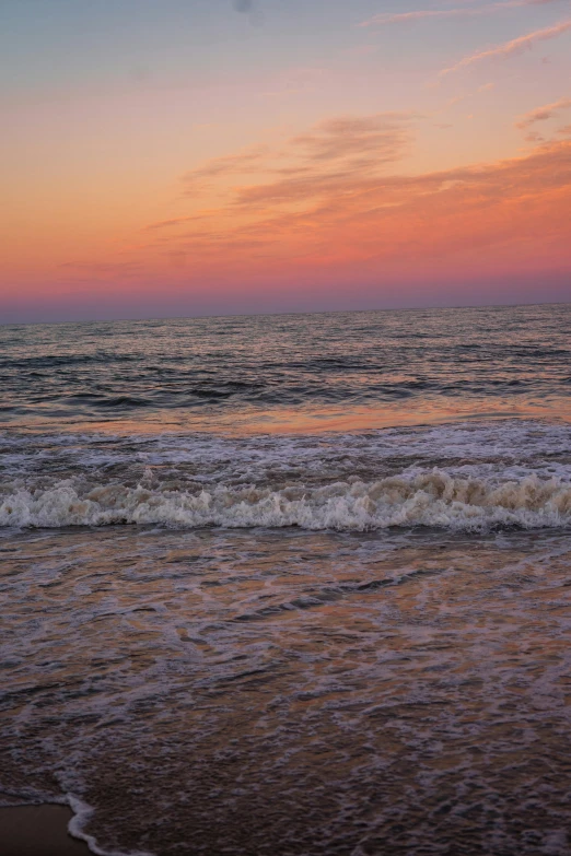 the sky above the ocean and a surfer holding a surfboard