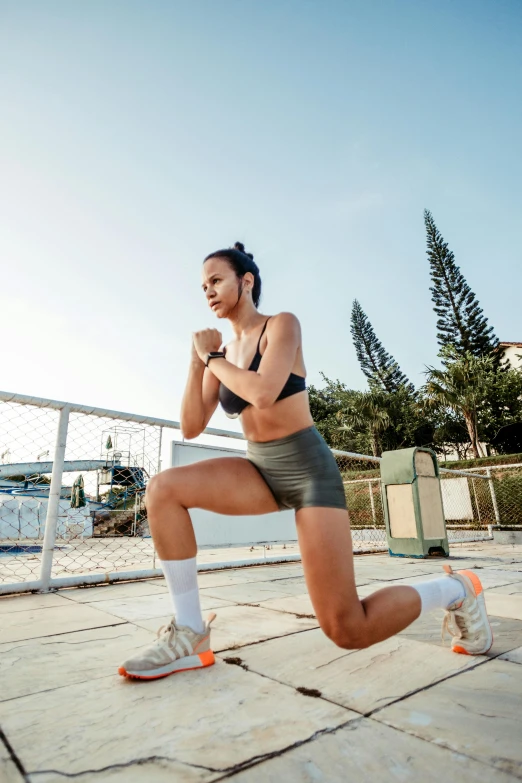 this is a woman in black sports  and grey athletic shorts squatting