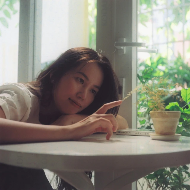 a young asian woman leaning on a table looking at her phone