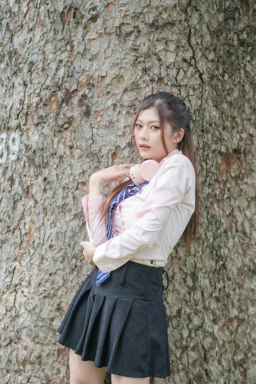 an asian girl with a skirt under a tree