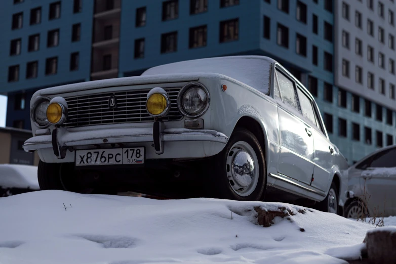 a car is parked in the snow outside a building