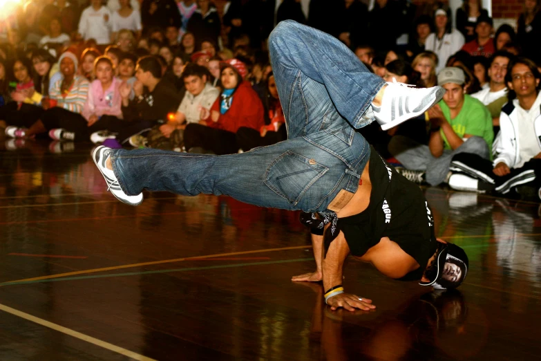 man doing an upside down dance on a hardwood floor