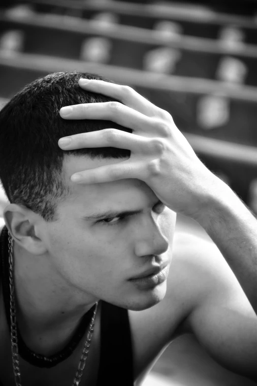 a man is looking up in front of the stands with his hands to his forehead