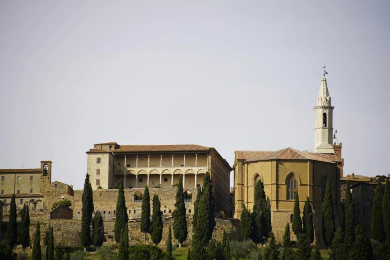 a clock tower stands on the top of the hilltop