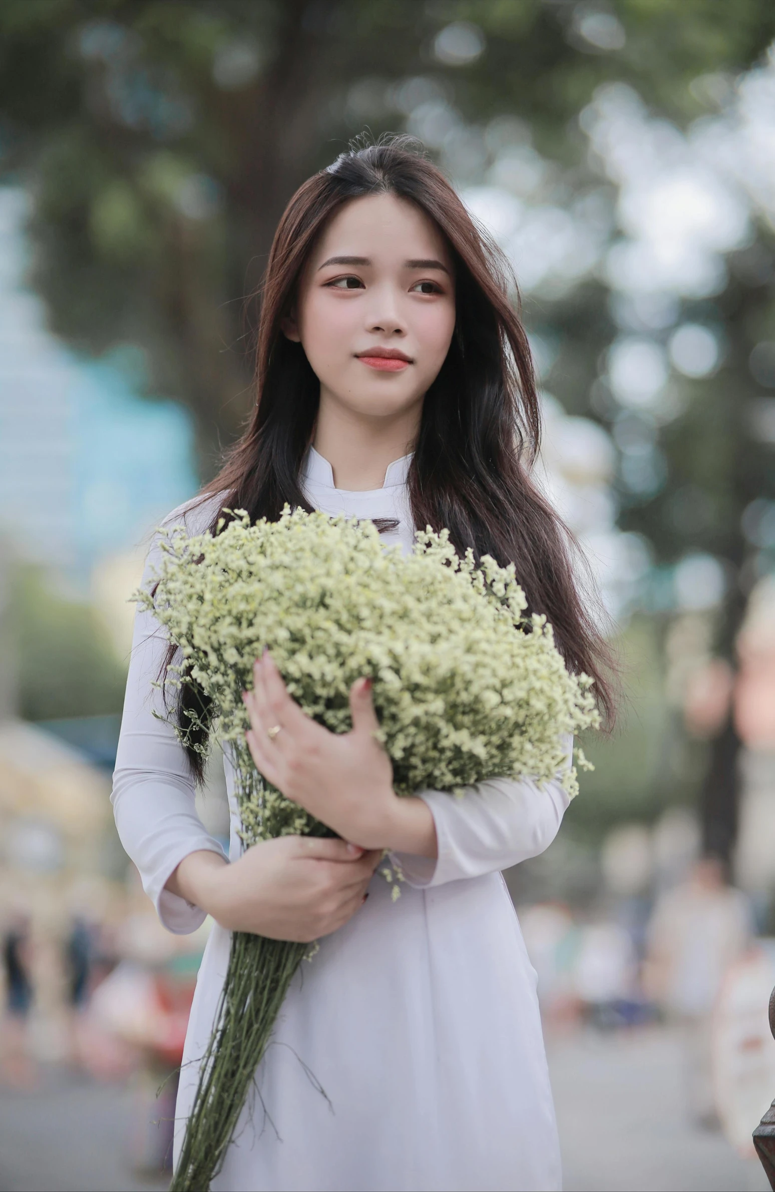 a woman in white holding some green plants