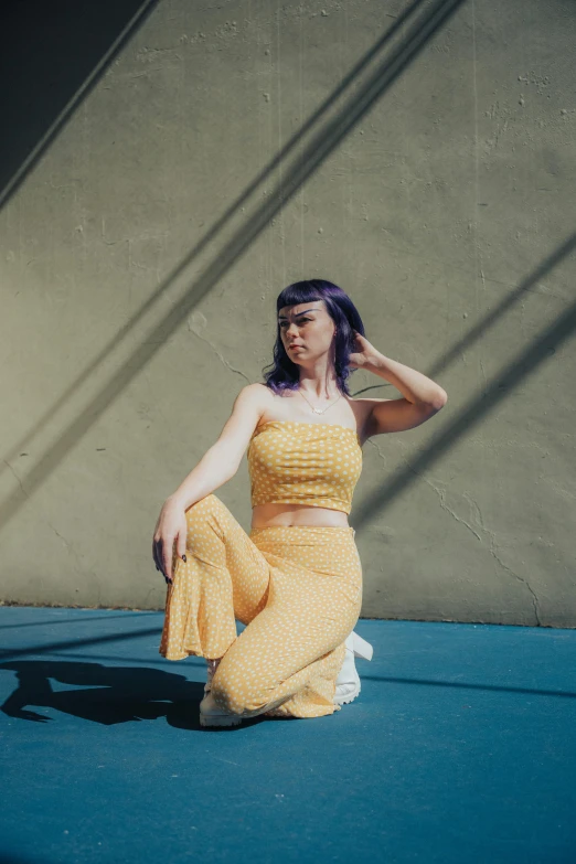 a woman posing on the ground and holding her hand up