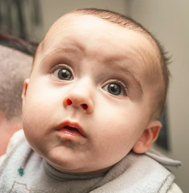 a baby is looking up to its master with a big smile