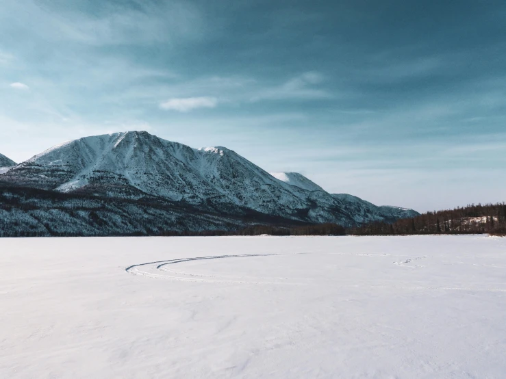 mountains and sky with snow and footprints in the snow