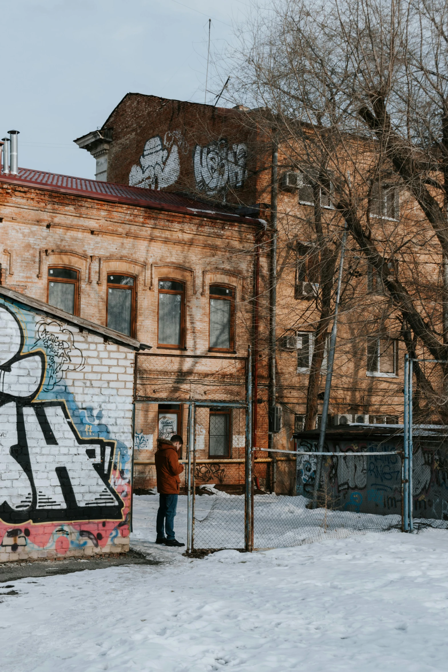 a man standing in front of a graffiti covered building