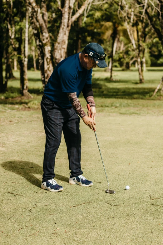 a man is using his golf club to hit the ball