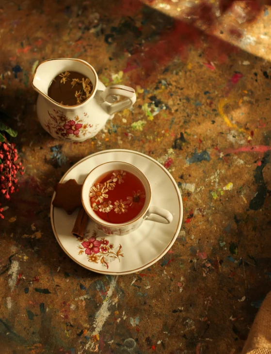 two white cup filled with tea next to saucer and spoon