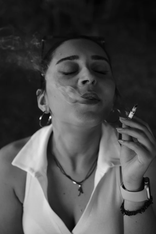 a woman smoking and laying down with her eyes closed