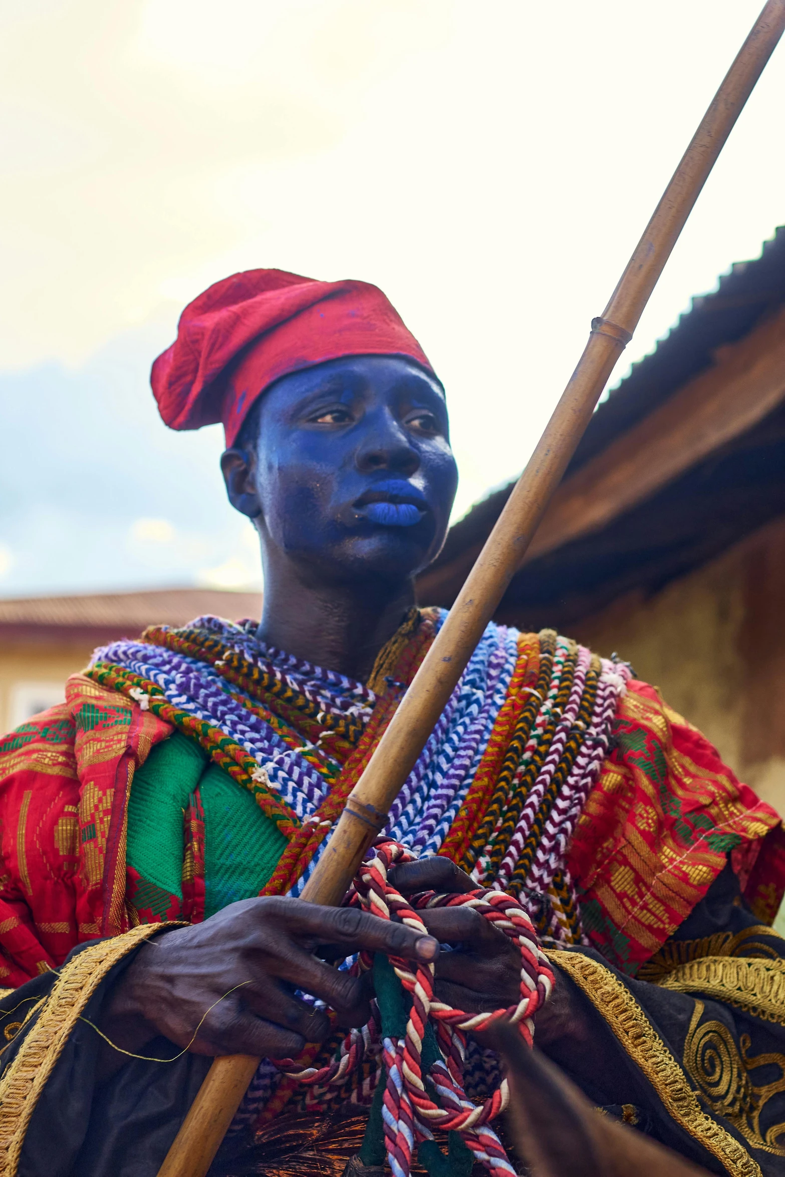 a person with blue paint holding a stick