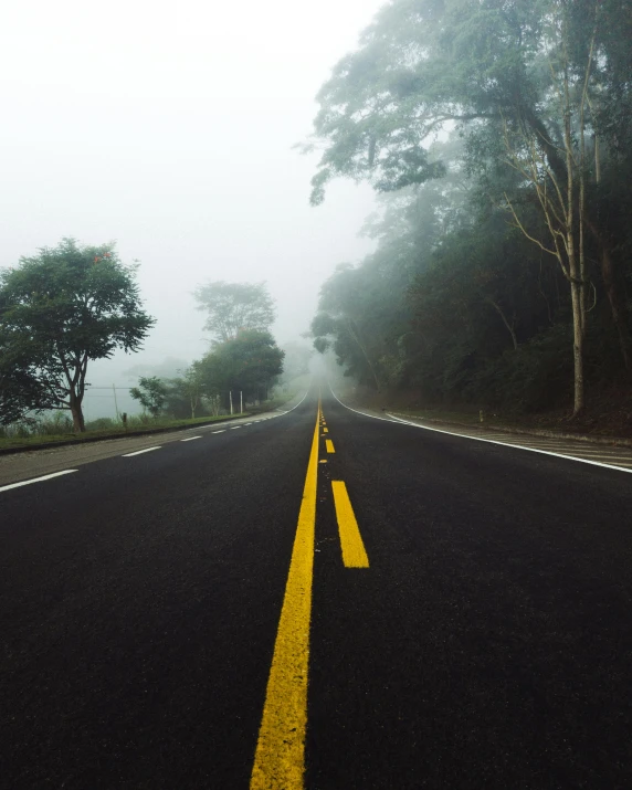 two yellow lines are drawn in the middle of a road