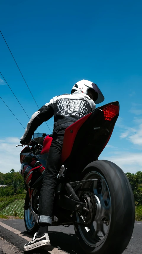 a person on a red motorcycle riding down the road