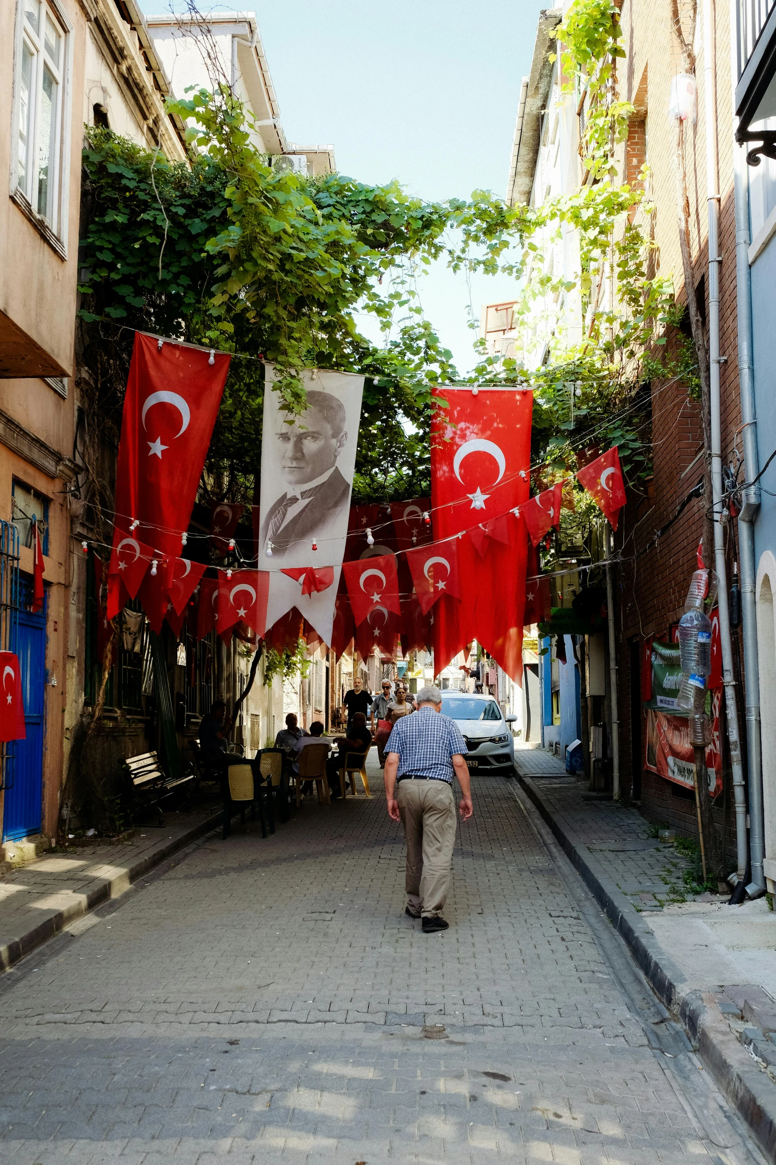 a man walks down a deserted city street lined with flags