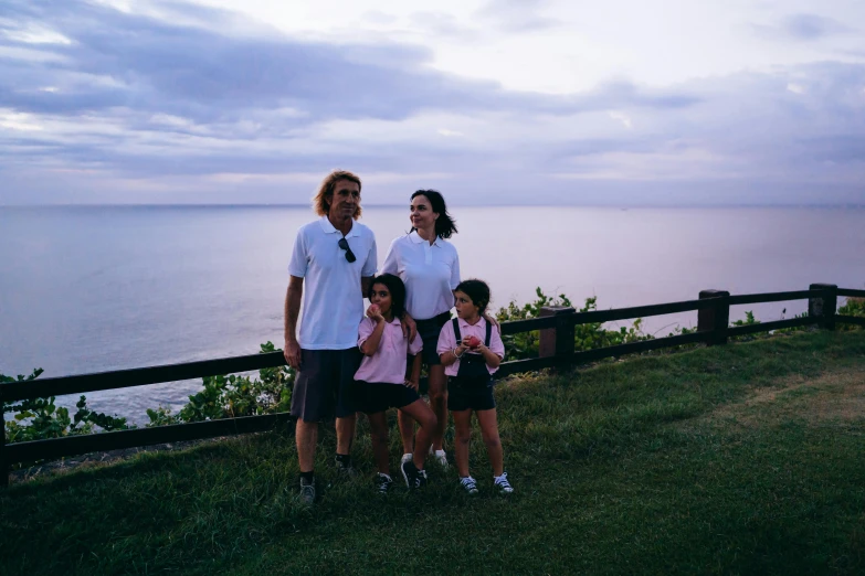 a family of three posing for a picture near the water