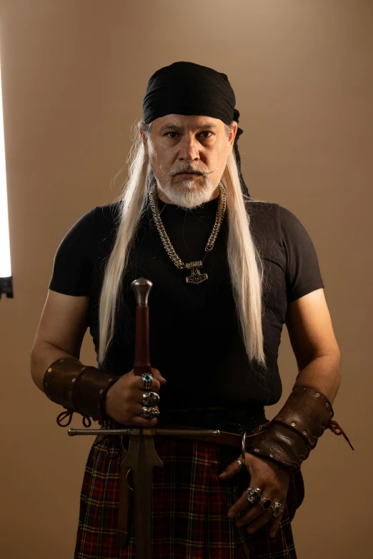 a man with white hair and wearing a kilt