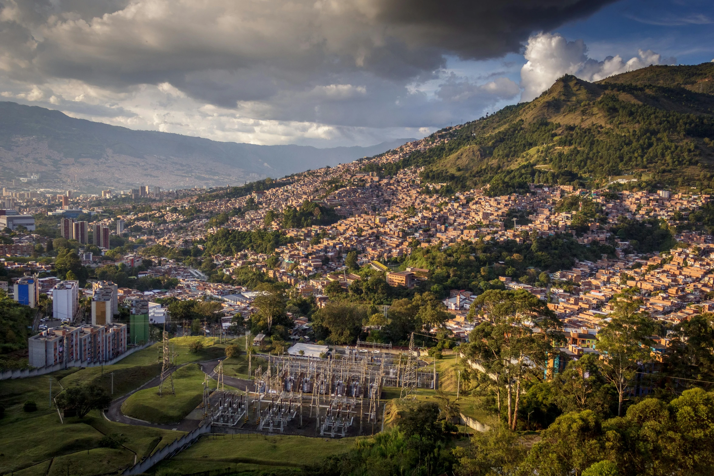 a town on top of a mountain under a cloudy sky