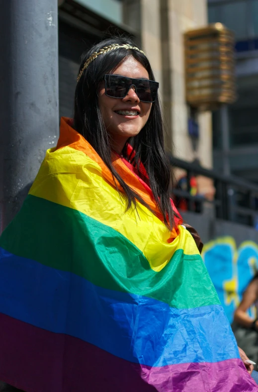 a woman with a rainbow striped ponc is standing