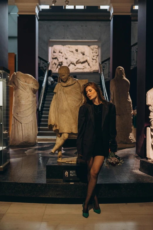 a woman stands in front of an ancient museum