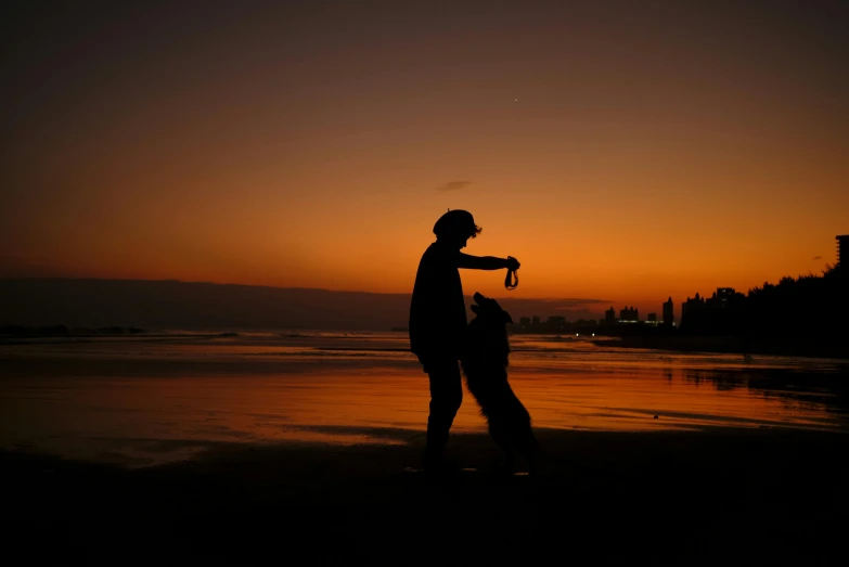 a woman pointing at the sun with her hand and dog