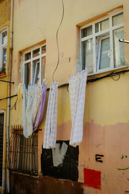 laundry hanging from clothes lines next to apartment building