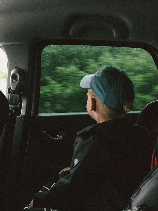 a man is sitting in his car looking out the window