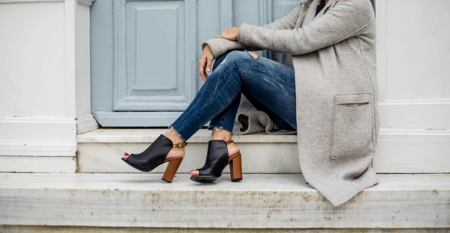 a woman wearing high heels sitting on steps