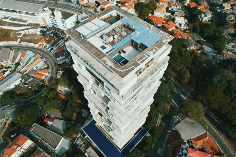 an aerial view of a modern white building, looking down onto the city