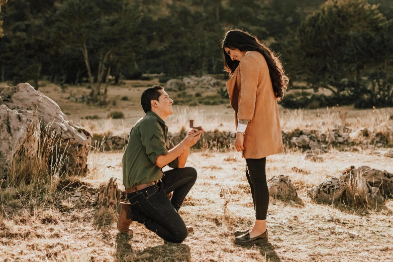 a young woman kneeling down to a man on the ground