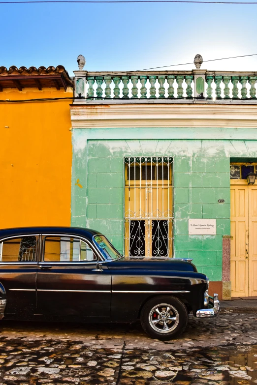 an old car parked outside a colorful building