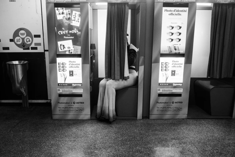 a person sits on an airplane seat in a ticket booth