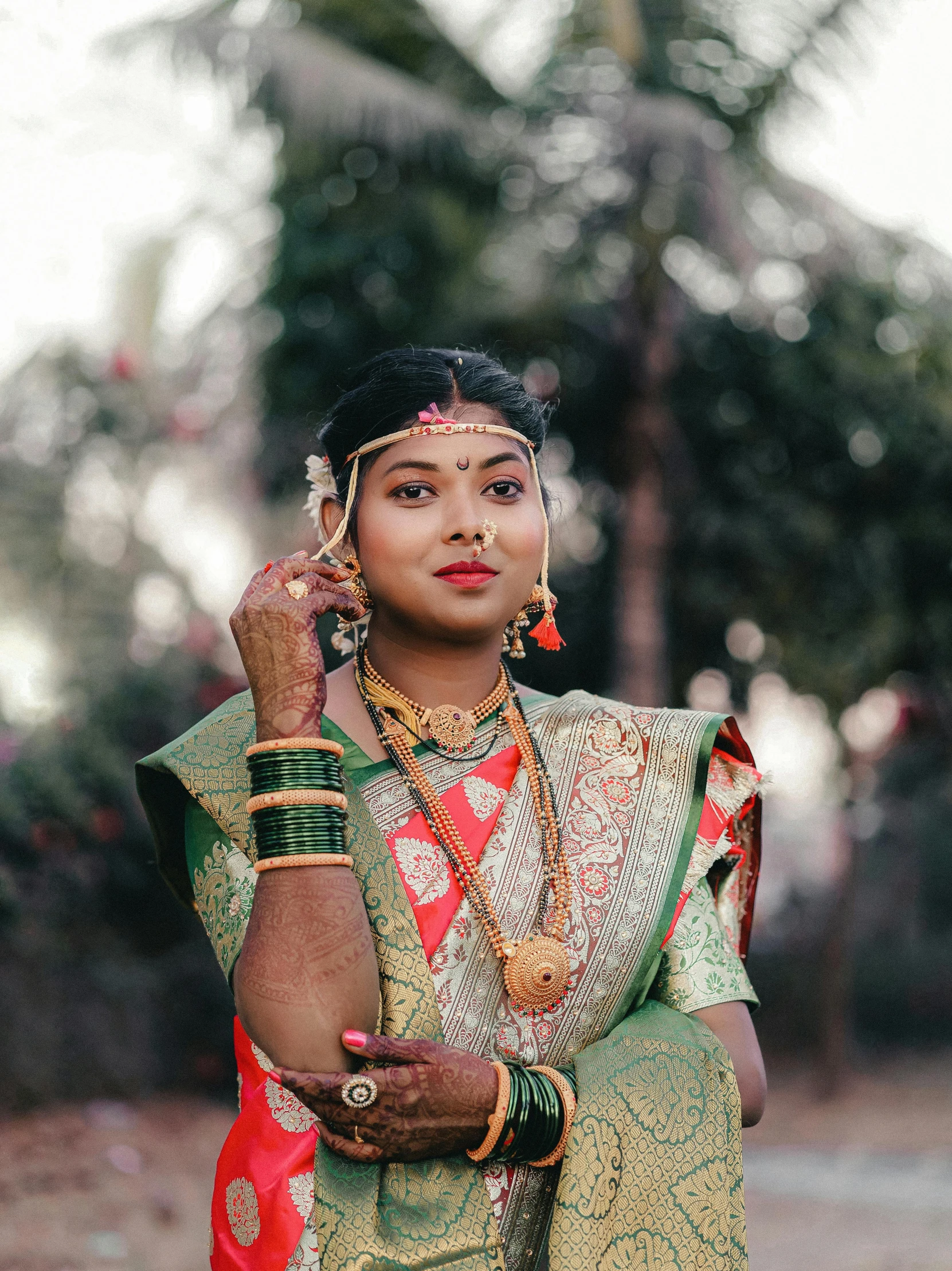 an indian woman wearing traditional sari holding her hands to her ear