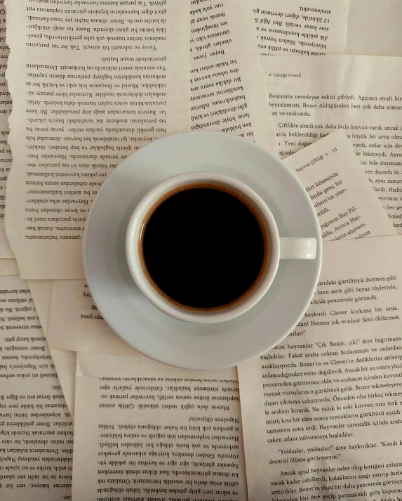 a coffee cup on top of some newspaper