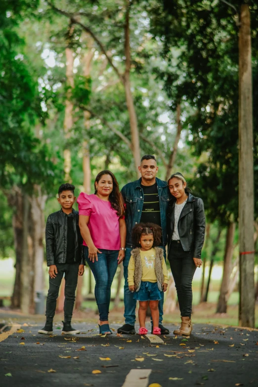 an adult, woman and children standing outside in a forest