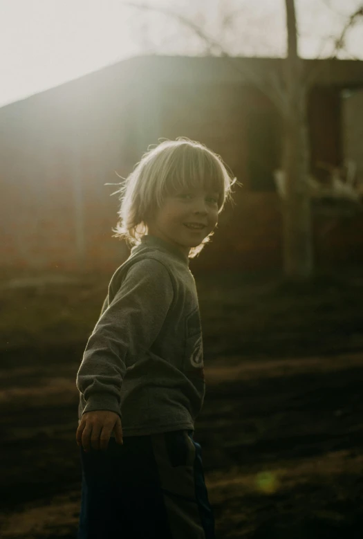 the boy is standing in the yard with no one around