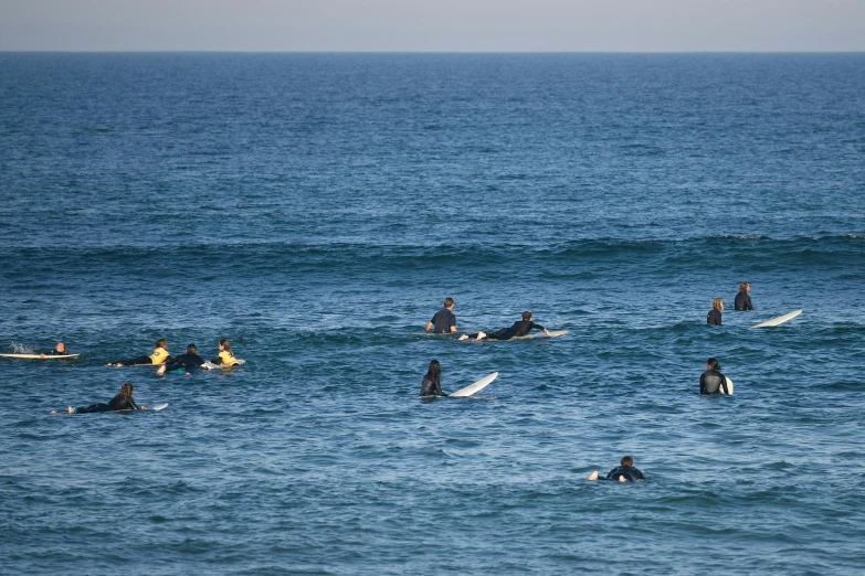 a group of people with surf boards paddling in the ocean