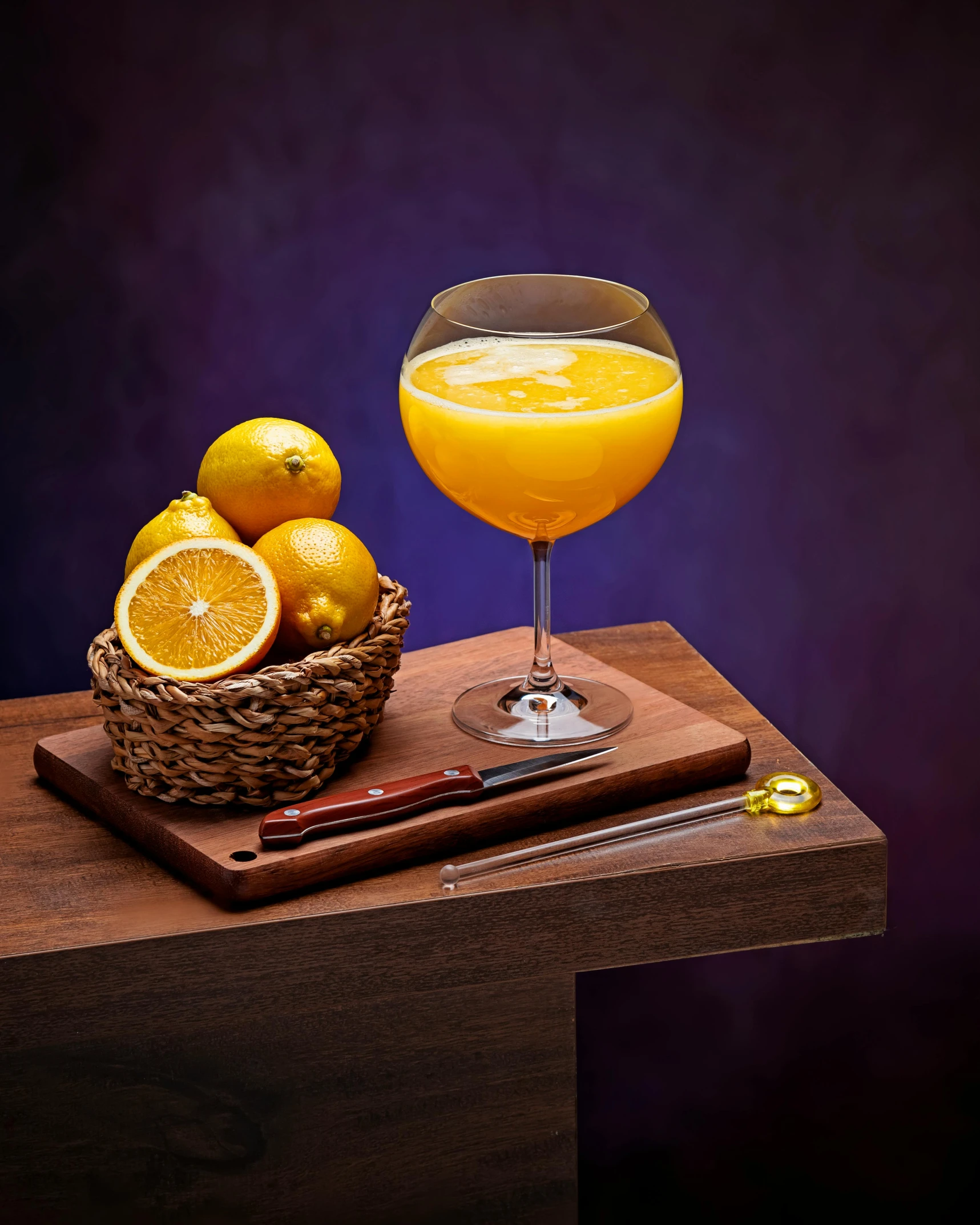 a bowl with a glass filled with a orange next to some fruit