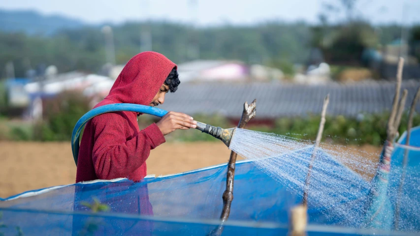 an image of a woman watering flowers outside