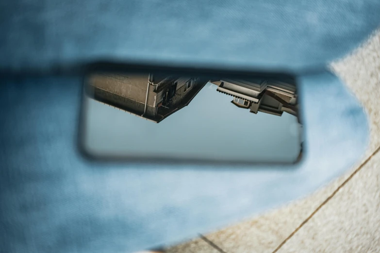 the image shows the back of a car with the mirror and vehicle's view in a rear view mirror