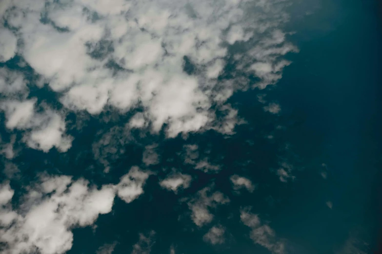 the sky has fluffy clouds and a jet airplane