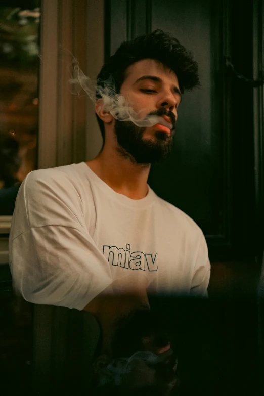 man in white shirt with a cigarette in front of him