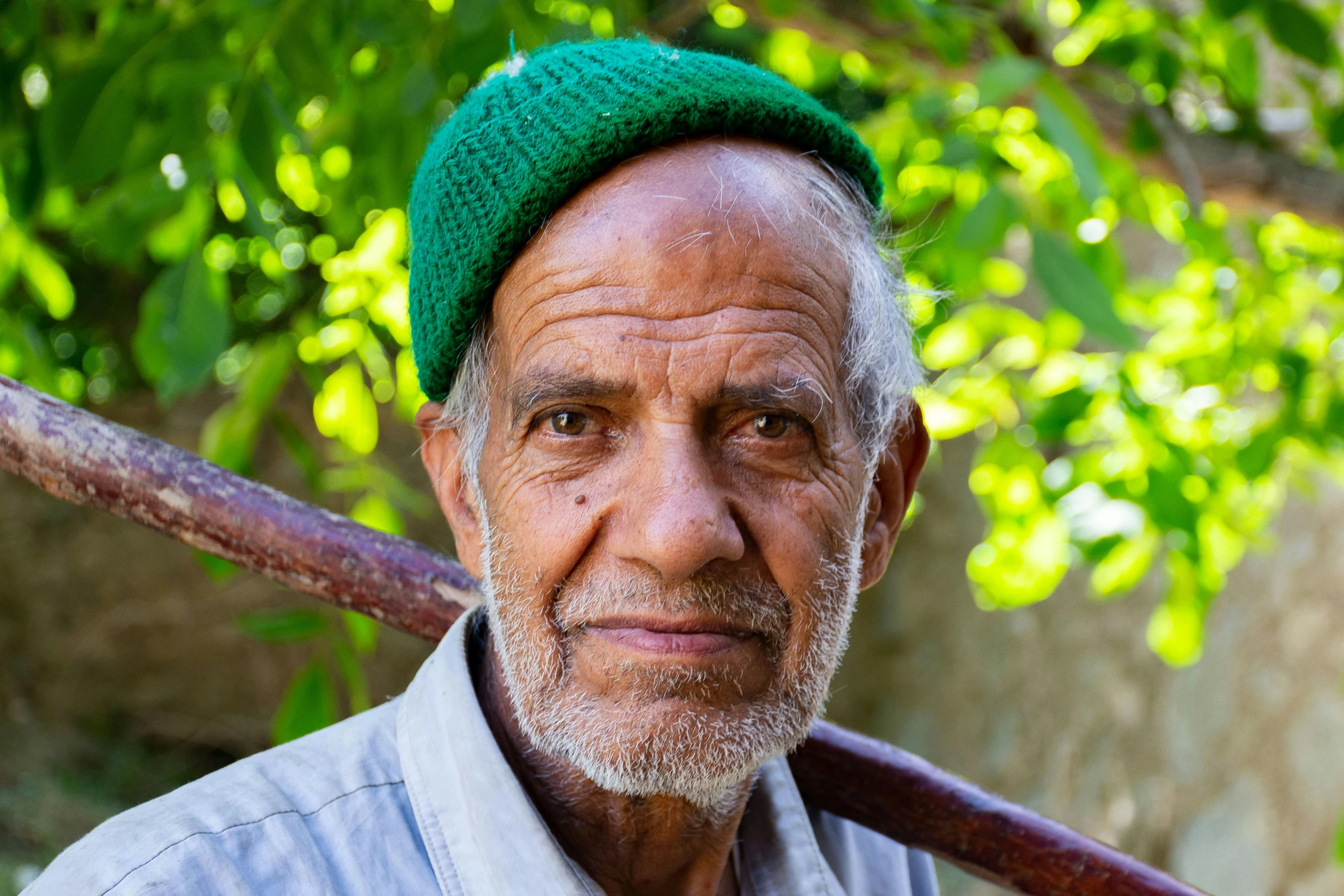 an older man with a green hat and a baseball bat