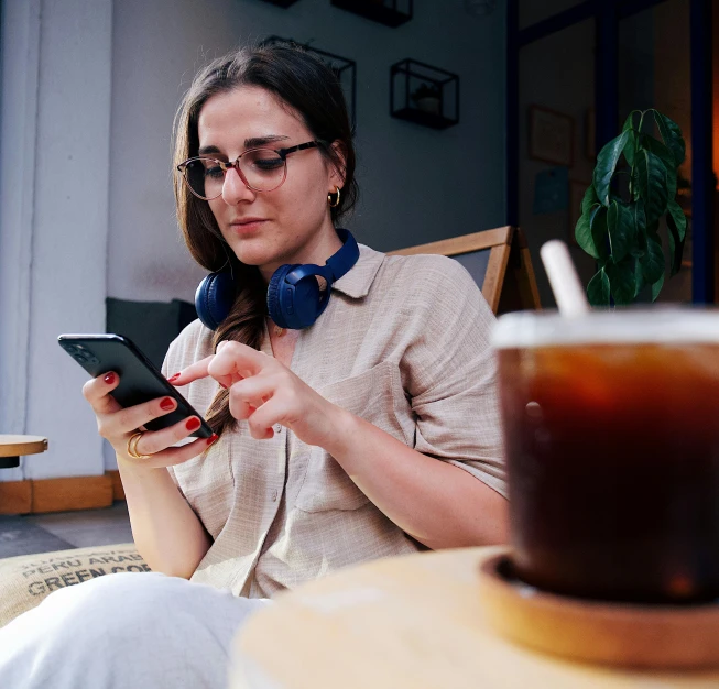 a young woman sitting with headphones and a tablet