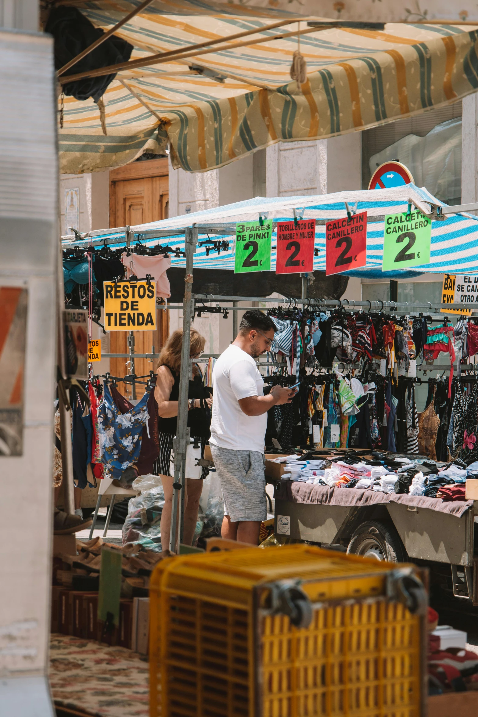 a man working on an umbrella in a market