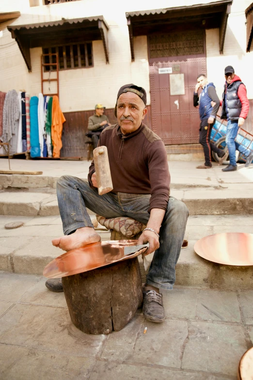 a man sits on top of a barrel