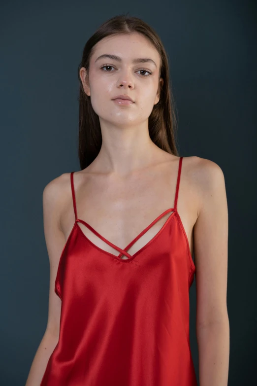 woman in red satin shirt with crossed strap looking at the camera