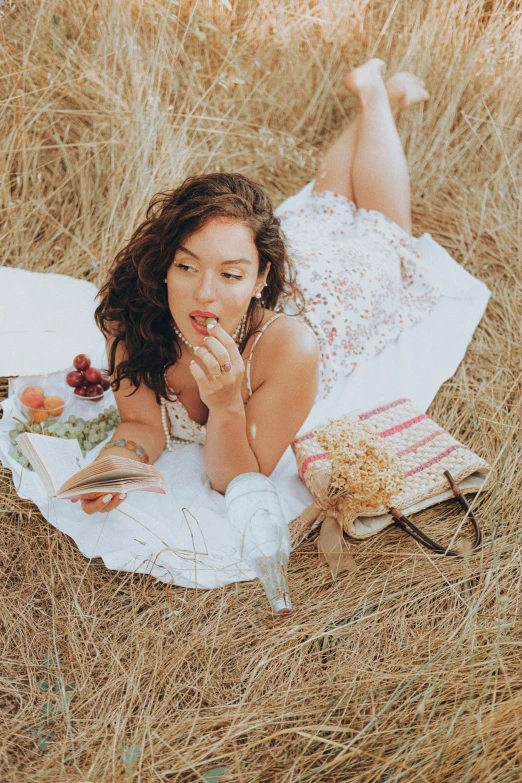 an asian woman in white laying on a rug in the grass