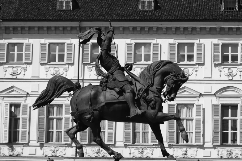 a statue of a man on a horse in front of an old building